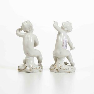 Coppia di figurine di putti, XX secolo.<BR>Porcellana. Marca: N con corona in blu.  - Asta Ceramiche - Associazione Nazionale - Case d'Asta italiane