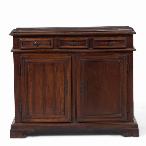 Credenza in noce, due ante pannellate e tre cassetti sottopiano. XVIII secolo  - Asta Antiquariato - Associazione Nazionale - Case d'Asta italiane