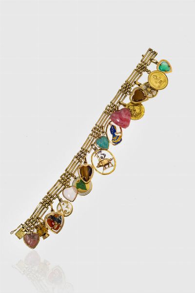 BRACCIALE : Peso gr 50 1 Lunghezza cm 19 in oro giallo con sedici charms pendenti di varie forme e misure  alcuni in pietre dure.  - Asta Gioielli  - Associazione Nazionale - Case d'Asta italiane