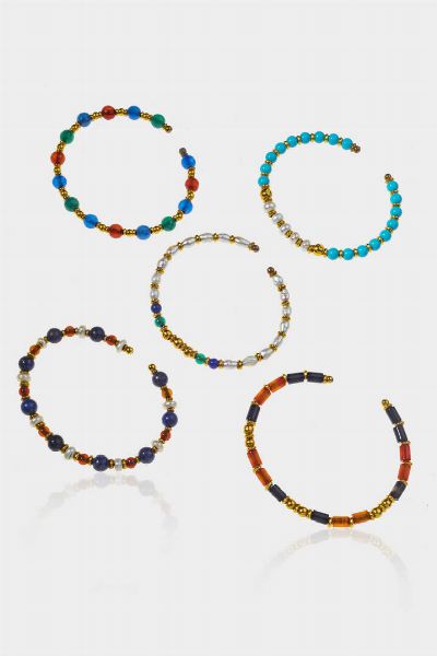 LOTTO DI CINQUE BRACCIALI : Peso complessivo gr 26 5 rigidi  con perle  pietre dure di varie forme e misure  perle di acqua dolce  pasta di turchese e pepite in oro  - Asta Gioielli  - Associazione Nazionale - Case d'Asta italiane