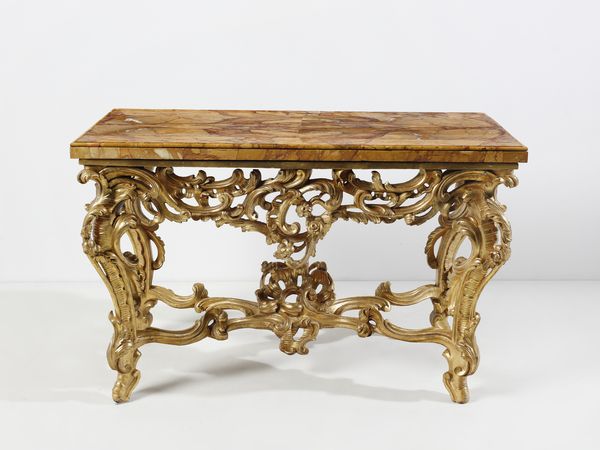 MANIFATTURA ROMANA DEL XVIII SECOLO : Console in legno intagliato e dorato, sostegni in forma di volute e racemi fitomorfi, gambe arcuate unite da traversa a crociera, piano sagomato lastronato in marmo giallo di Siena  - Asta Asta 492 | ARTE ANTICA E DEL XIX SECOLO - Arte antica e antiquariato Tradizionale - Associazione Nazionale - Case d'Asta italiane