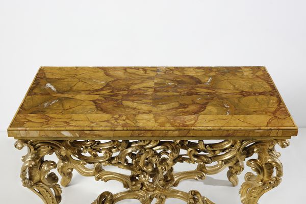 MANIFATTURA ROMANA DEL XVIII SECOLO : Console in legno intagliato e dorato, sostegni in forma di volute e racemi fitomorfi, gambe arcuate unite da traversa a crociera, piano sagomato lastronato in marmo giallo di Siena  - Asta Asta 492 | ARTE ANTICA E DEL XIX SECOLO - Arte antica e antiquariato Tradizionale - Associazione Nazionale - Case d'Asta italiane