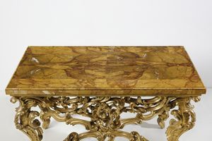 MANIFATTURA ROMANA DEL XVIII SECOLO : Console in legno intagliato e dorato, sostegni in forma di volute e racemi fitomorfi, gambe arcuate unite da traversa a crociera, piano sagomato lastronato in marmo giallo di Siena  - Asta Asta 492 | ARTE ANTICA E DEL XIX SECOLO - Arte antica e antiquariato Tradizionale - Associazione Nazionale - Case d'Asta italiane