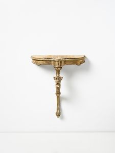 MANIFATTURA DEL XVIII-XIX SECOLO - Consolle in legno intagliato e dorato, fusto con decoro a maschera grottesca, piano a incasso in marmo giallo