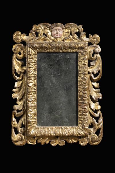 PICCOLA SPECCHIERA : 44x32 cm in legno dorato  decorata a volute e battuta decorata a foglie  al centro volto di cherubino  XVII secolo  Lombardia o Spagna (?)  - Asta Asta 198 Antiquariato - Associazione Nazionale - Case d'Asta italiane