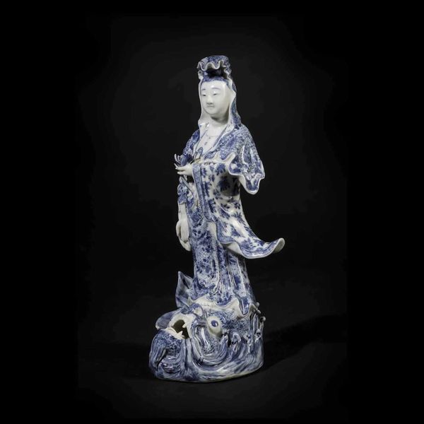 Figura di Guanyin stante su pesce in porcellana bianca e blu, Giappone, periodo Meiji (1868-1912)  - Asta Fine Chinese Works of Art - Associazione Nazionale - Case d'Asta italiane