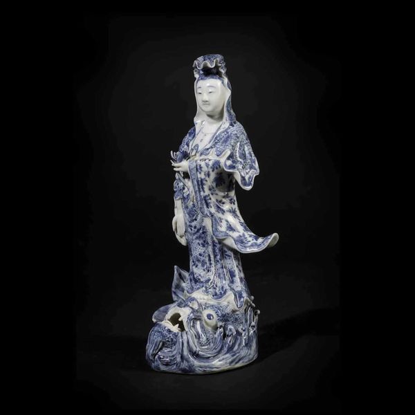 Figura di Guanyin stante su pesce in porcellana bianca e blu, Giappone, periodo Meiji (1868-1912)  - Asta Chinese Works of Art - Associazione Nazionale - Case d'Asta italiane